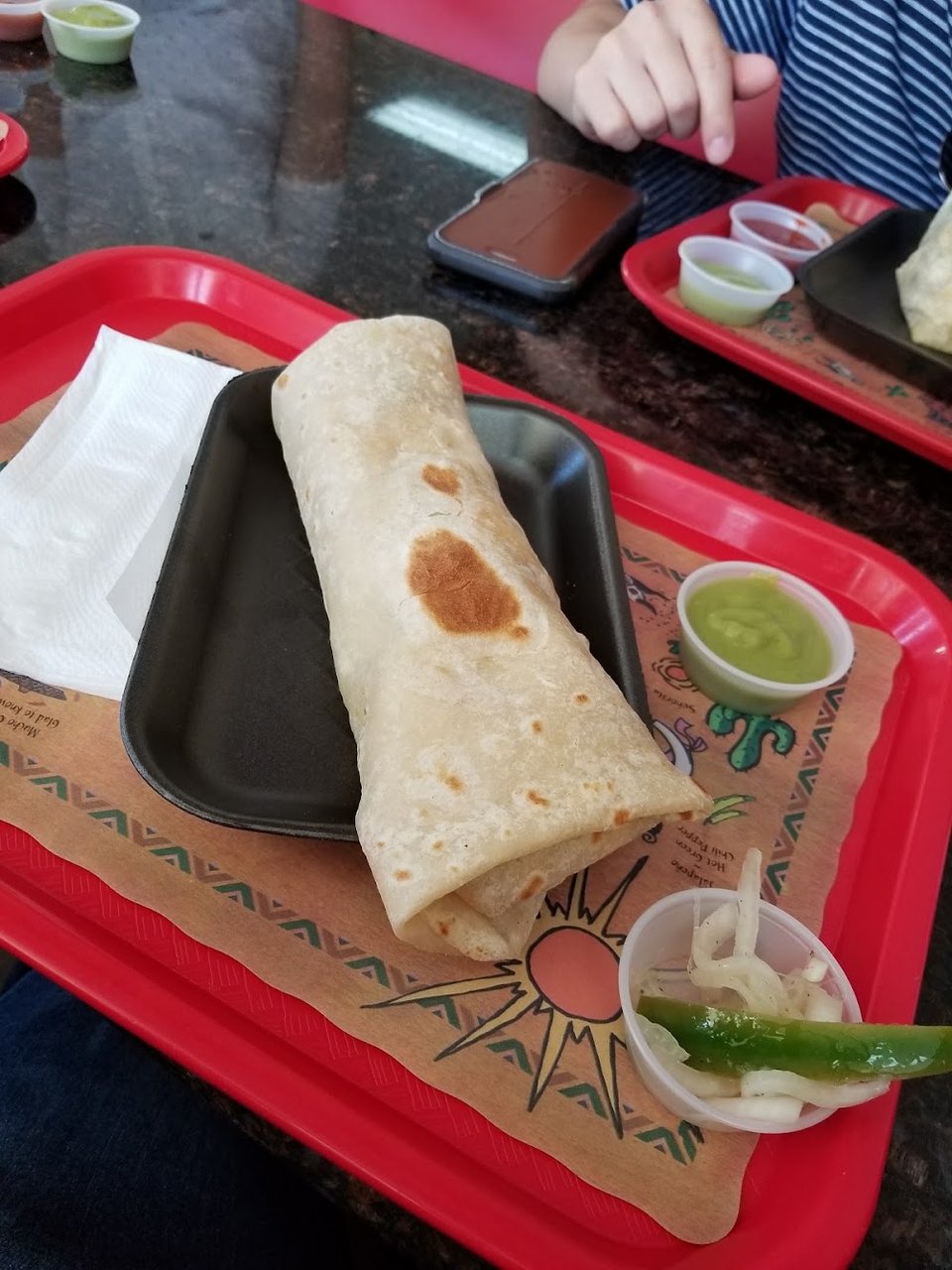Menu board with tacos and breakfast burritos.
