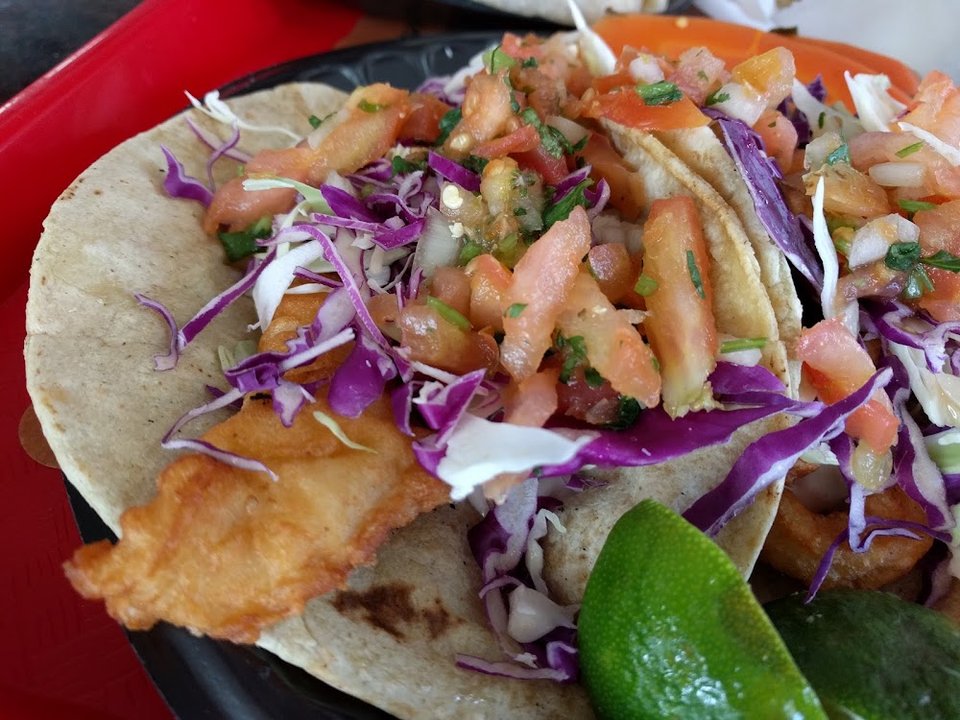 Menu board with tacos and breakfast burritos.