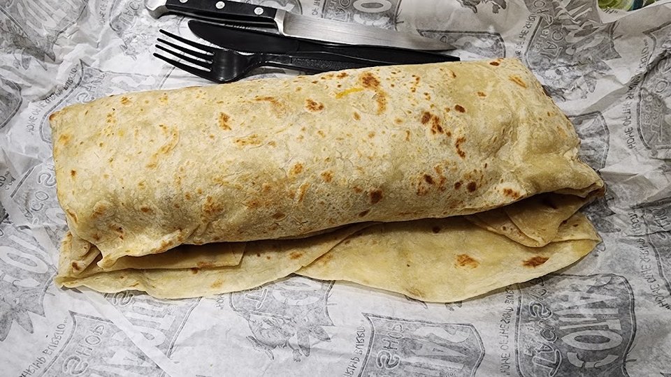 Printed menu showing burritos, tacos, and plates.
